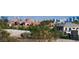 Beautiful home with tile roof and lush landscaping featuring a view of the Las Vegas skyline in the background at 9533 Orient Express Ct, Las Vegas, NV 89145