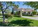 Beautiful two-story home with a well-manicured lawn, lush landscaping, and paved driveway at 9533 Orient Express Ct, Las Vegas, NV 89145