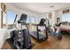 Bright home gym featuring an elliptical, treadmill, and stationary bike, with views through multiple windows and doors at 9533 Orient Express Ct, Las Vegas, NV 89145