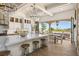 Open-concept kitchen with marble island, pendant lighting, and bi-fold doors to a covered patio at 9533 Orient Express Ct, Las Vegas, NV 89145
