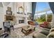 Beautiful living room with a stone fireplace, tall windows, and classic furnishings for comfortable living at 9533 Orient Express Ct, Las Vegas, NV 89145