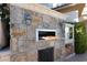 Outdoor pizza oven with decorative stone surround, counter space, and wood storage, perfect for outdoor dining at 9533 Orient Express Ct, Las Vegas, NV 89145