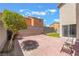 A beautiful backyard, featuring a brick fence, cozy seating, vibrant plants and grass, and glass door at 9785 Iron Mine St, Las Vegas, NV 89183