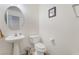 Cozy half-bathroom with pedestal sink, toilet, and a decorative mirror at 9785 Iron Mine St, Las Vegas, NV 89183