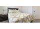 Comfortable bed with stylish quilt and matching pillows, and a nightstand with a lamp at 9785 Iron Mine St, Las Vegas, NV 89183
