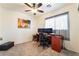 Comfortable bedroom features neutral carpeting and a ceiling fan above a functional workspace at 9785 Iron Mine St, Las Vegas, NV 89183