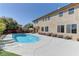 A beautiful backyard features a refreshing pool, surrounded by a well-maintained patio, plants, and a covered lounge area at 9992 Sky Parlor Rd, Las Vegas, NV 89178