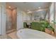 Relaxing bathroom features a soaking tub, shower, and vanity with a plant at 9992 Sky Parlor Rd, Las Vegas, NV 89178