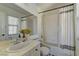 Bright bathroom featuring a shower-tub combo, white tile, and a large mirror at 9992 Sky Parlor Rd, Las Vegas, NV 89178