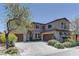 Beautiful two-story home featuring a lush yard, desert landscaping, and multi-car driveway at 9992 Sky Parlor Rd, Las Vegas, NV 89178