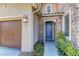 Close-up of front door with stone accent, muted blue color, and lush green ground cover at 9992 Sky Parlor Rd, Las Vegas, NV 89178
