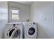 Bright laundry room featuring a window and modern washer and dryer units at 9992 Sky Parlor Rd, Las Vegas, NV 89178