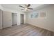 Bright bedroom with light gray plank floors, a ceiling fan, and double door closets at 10 Yew Ave, Las Vegas, NV 89110