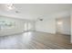 Spacious living room with light gray plank floors, a ceiling fan, and access to backyard pool at 10 Yew Ave, Las Vegas, NV 89110