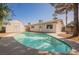 Backyard pool with tanning deck and surrounded by lush landscaping and a private storage shed at 10 Yew Ave, Las Vegas, NV 89110