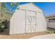 Charming white shed in the backyard offers convenient storage and complements the home's style at 10 Yew Ave, Las Vegas, NV 89110