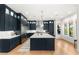 Stylish kitchen with navy blue cabinets, a large island, stainless steel appliances, and modern pendant lighting at 10717 Beringer Dr, Las Vegas, NV 89144