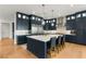 Modern kitchen boasts navy cabinets, stainless steel appliances, an island with seating, and pendant lights at 10717 Beringer Dr, Las Vegas, NV 89144