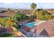 Aerial view of a backyard featuring a sparkling pool, spa, covered patio, and mature trees, creating a private oasis at 1078 Sandstone Canyon St, Henderson, NV 89012