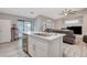 Bright kitchen island with breakfast bar seating, wood floors, and flows into living area at 1078 Sandstone Canyon St, Henderson, NV 89012