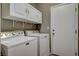 Functional laundry room with washer, dryer, and upper cabinets at 1078 Sandstone Canyon St, Henderson, NV 89012