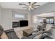 Spacious living room featuring a fireplace, large ceiling fan, and gray leather seating at 1078 Sandstone Canyon St, Henderson, NV 89012