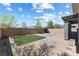 This backyard has grass, rocks, and concrete tiles, all surrounded by a brick wall at 10925 Jordyn Hill St, Las Vegas, NV 89141