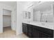 Bright bathroom with double sinks, dark wood cabinets, and a shower at 10925 Jordyn Hill St, Las Vegas, NV 89141