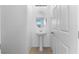 Well-lit half bathroom with a pedestal sink, an oval mirror, and crisp white walls at 10925 Jordyn Hill St, Las Vegas, NV 89141