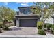 Charming gray home with a two-car garage, a brick driveway, and neatly manicured landscaping at 10925 Jordyn Hill St, Las Vegas, NV 89141