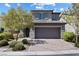 Charming two-story home featuring stone accents, gray siding, a brick driveway, and a two-car garage at 10925 Jordyn Hill St, Las Vegas, NV 89141