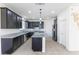 Modern kitchen with black cabinets, granite countertops, and a center island at 10925 Jordyn Hill St, Las Vegas, NV 89141