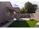 A backyard featuring synthetic grass, paver patios, a covered area, and stucco privacy walls at 1100 Warm Canyon Way, Las Vegas, NV 89123