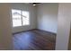 Bright bedroom featuring wood-look floors, a ceiling fan, and a window with neighborhood views at 1100 Warm Canyon Way, Las Vegas, NV 89123