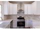 This modern kitchen features white cabinets, stone countertops, and stainless steel appliances at 1100 Warm Canyon Way, Las Vegas, NV 89123