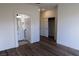 Bright main bedroom with wood-look floors, a ceiling fan, and access to an ensuite bathroom at 1100 Warm Canyon Way, Las Vegas, NV 89123
