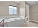 Corner soaking tub with tile surround and a window offering natural light at 11274 Felice Cohn Ct, Las Vegas, NV 89179
