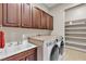 Well-organized laundry room with custom cabinets, folding counter, utility sink and shelving at 11274 Felice Cohn Ct, Las Vegas, NV 89179