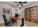 Home office featuring a wood desk, leather chair, ceiling fan, and built-in shelving at 11274 Felice Cohn Ct, Las Vegas, NV 89179