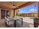 Covered patio with table and chairs overlooking a pool and garden at 11274 Felice Cohn Ct, Las Vegas, NV 89179