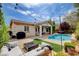 Well-equipped backyard with pool, patio, stylish outdoor furniture, fire pit, string lights, and grill at 11342 Early Sun Ct, Las Vegas, NV 89135