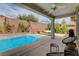 Lush backyard featuring a swimming pool, landscaped area, spa, patio with comfortable seating, and grill at 11342 Early Sun Ct, Las Vegas, NV 89135