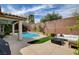 Private backyard features a sparkling pool, artificial turf, brick wall, and comfortable outdoor seating at 11342 Early Sun Ct, Las Vegas, NV 89135