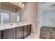 This bathroom features a large mirror over a double sink vanity with dark cabinets at 11342 Early Sun Ct, Las Vegas, NV 89135