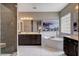 Luxurious bathroom featuring a walk-in shower, a soaking tub, and double sinks with elegant fixtures and finishes at 11342 Early Sun Ct, Las Vegas, NV 89135