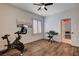 Hardwood bedroom featuring a ceiling fan, shutters on windows, exercise bike, and keyboard at 11342 Early Sun Ct, Las Vegas, NV 89135