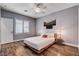Stylish bedroom with wood floors, a platform bed, neutral decor, and large window with plantation shutters at 11342 Early Sun Ct, Las Vegas, NV 89135