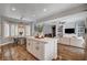 Open-concept kitchen with island seating flows into a dining area and comfortable living room with custom built-ins at 11342 Early Sun Ct, Las Vegas, NV 89135