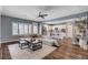 Bright living room with a ceiling fan, large sofa, and an open flow to the kitchen at 11342 Early Sun Ct, Las Vegas, NV 89135