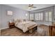 Inviting main bedroom with ample natural light, wood floors, a seating area and a decorative ceiling fan at 11342 Early Sun Ct, Las Vegas, NV 89135